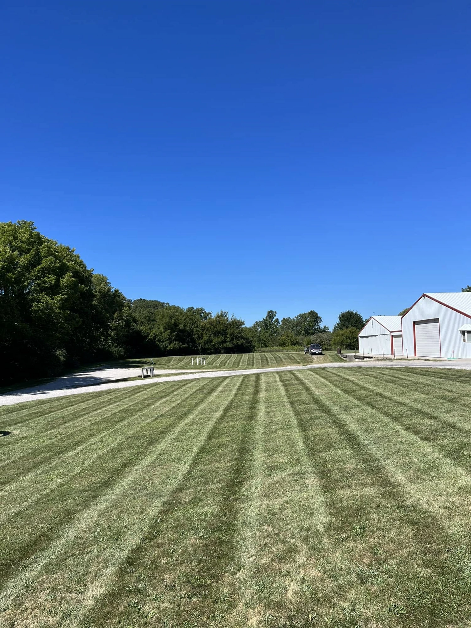 Freshly striped commercial lawn with a metal barn in the background